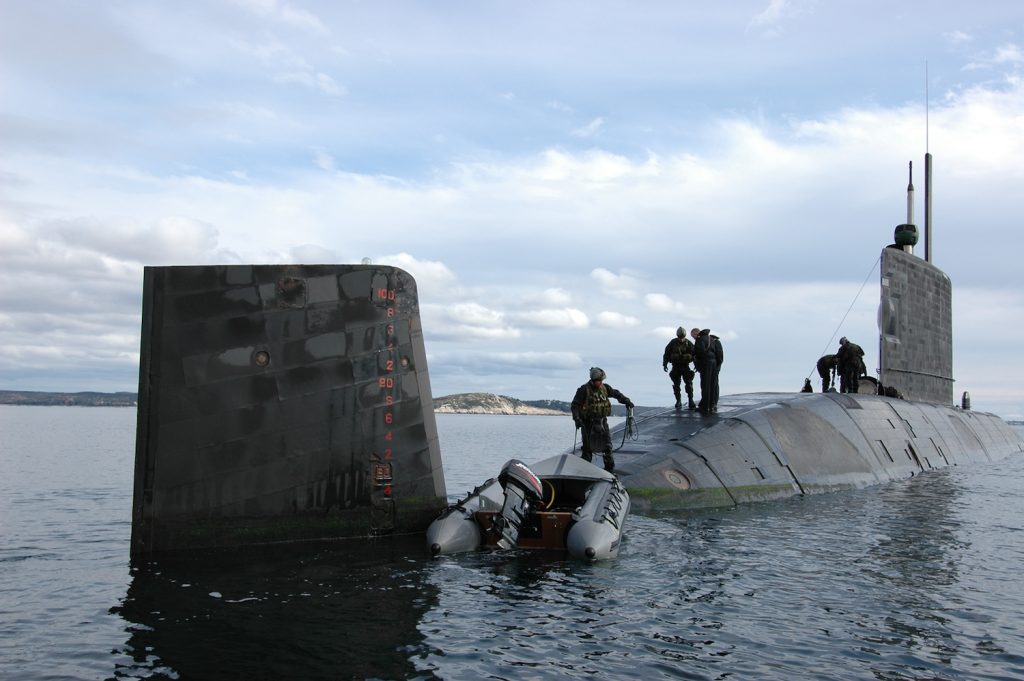 members of the Royal Canadian Navy work on a submarine.
